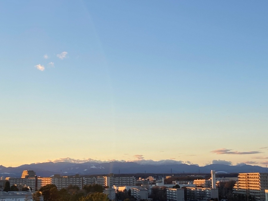 夕陽を浴びるマンション群と向こうの山々