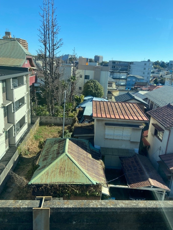 駅のホームから見える賃貸マンションと廃屋